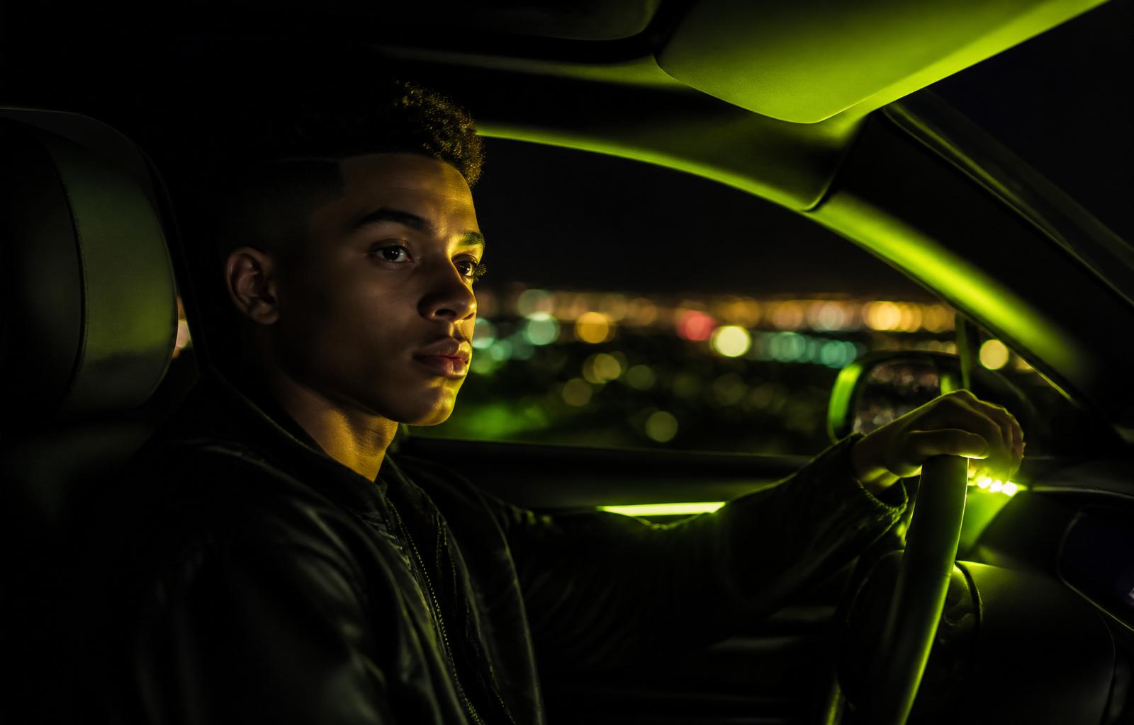 Young South African driver at night, illuminated by electric lime